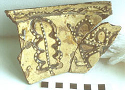 Fig 5 Fragment of a deep bowl, white slip-coated with trailed brown slip design and white slip jewelling. Excavated from the kiln site at Brookhill Pottery 