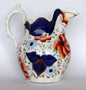 ‘Drape’ patterned jug showing lustre appearing as copper when painted on blue and pink when painted on white.